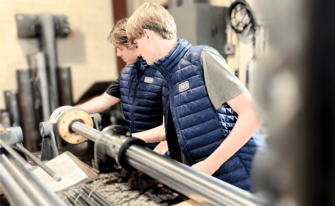 Owen McIntosh and Matt Russell operating industrial machinery